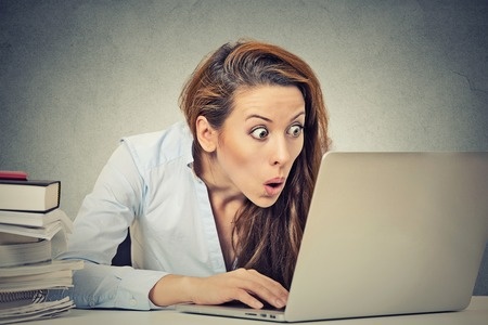 Young business woman looking at her laptop computer screen happy  surprised face expression emotion feelings 